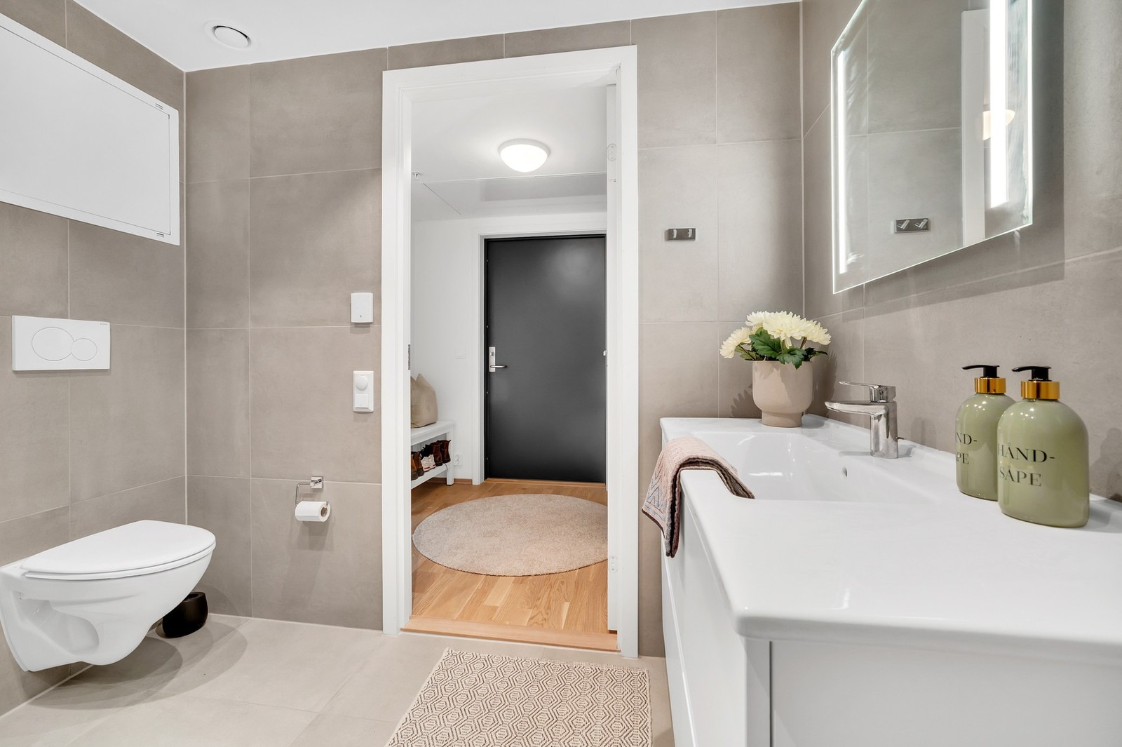 Vegghengt toalett og innfellbare dusjdører.